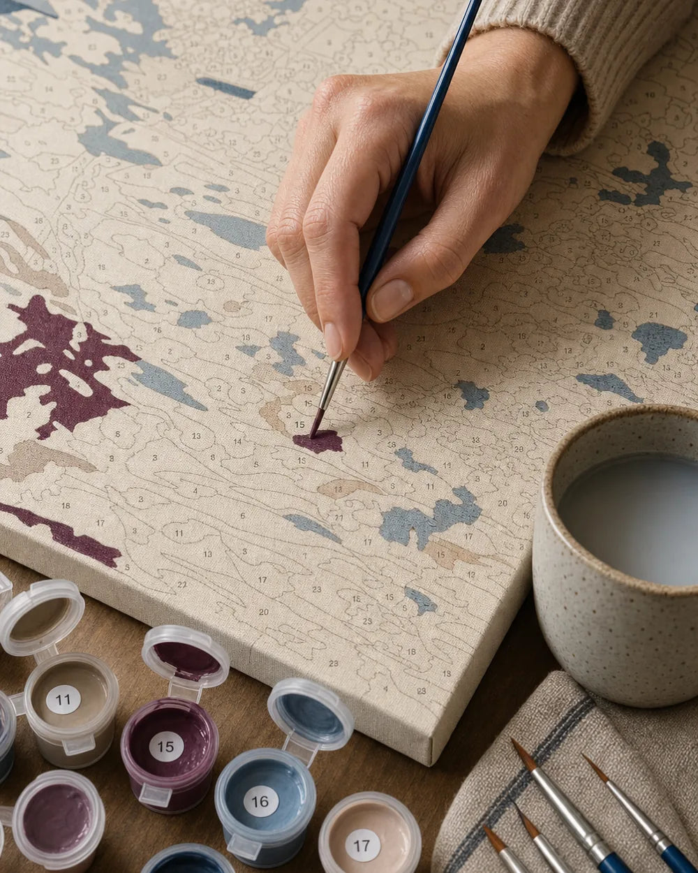Hand painting a numbered canvas with the included brush